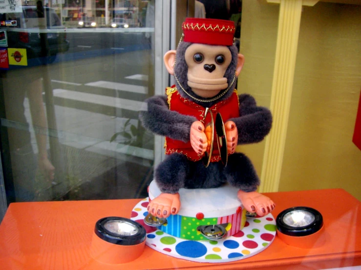 a monkey sitting on a plate with speakers