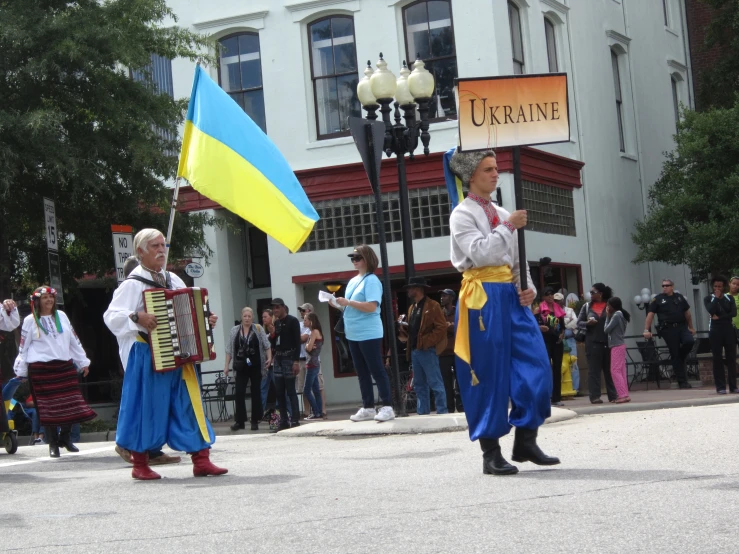a man and woman are carrying flags at a parade