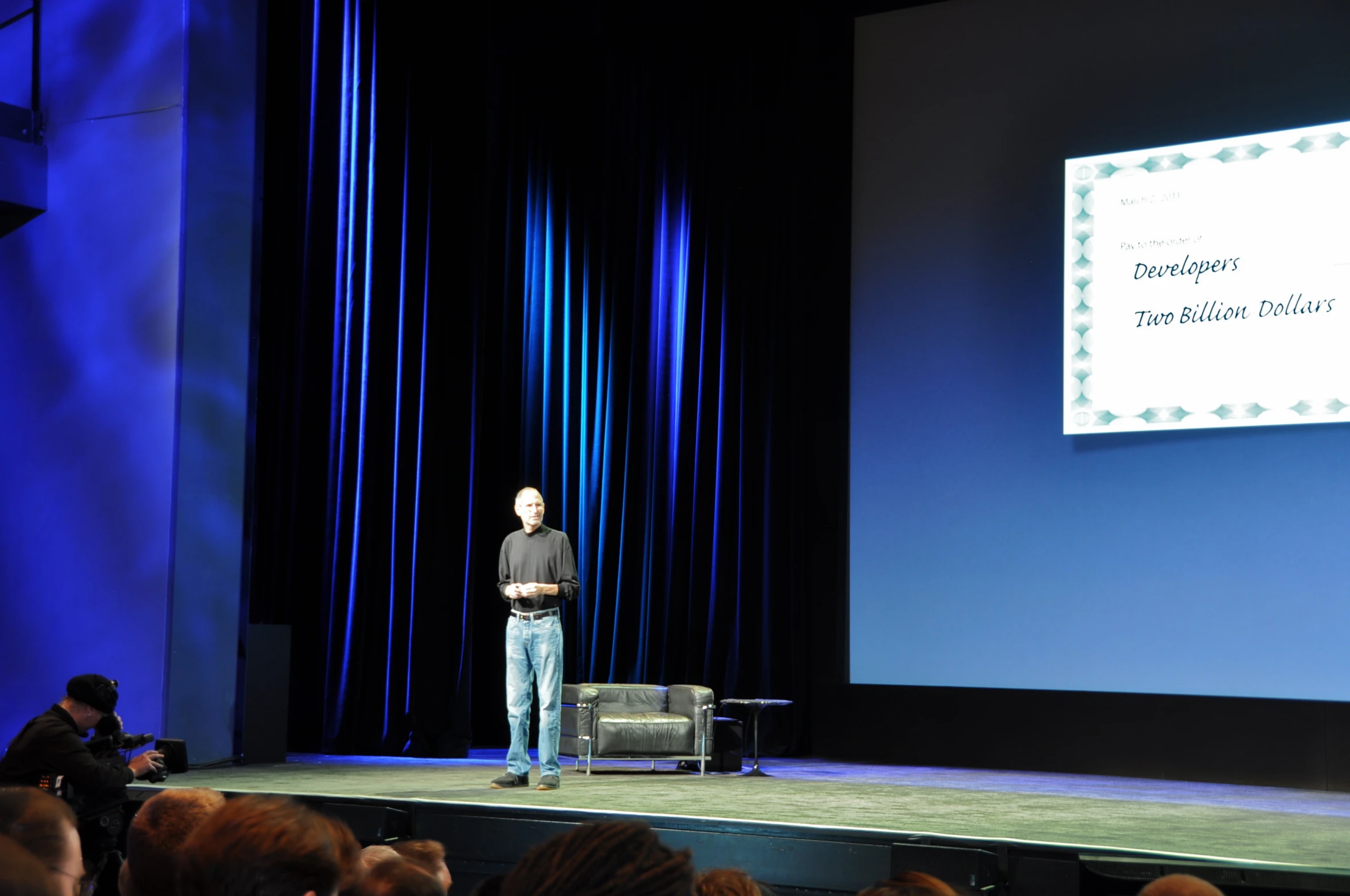 the man is standing on the stage speaking