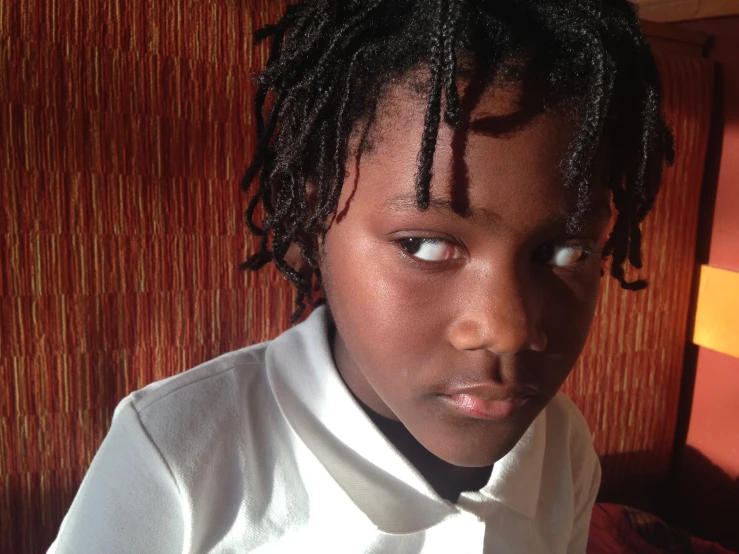 a young black boy wearing a white shirt and bow tie