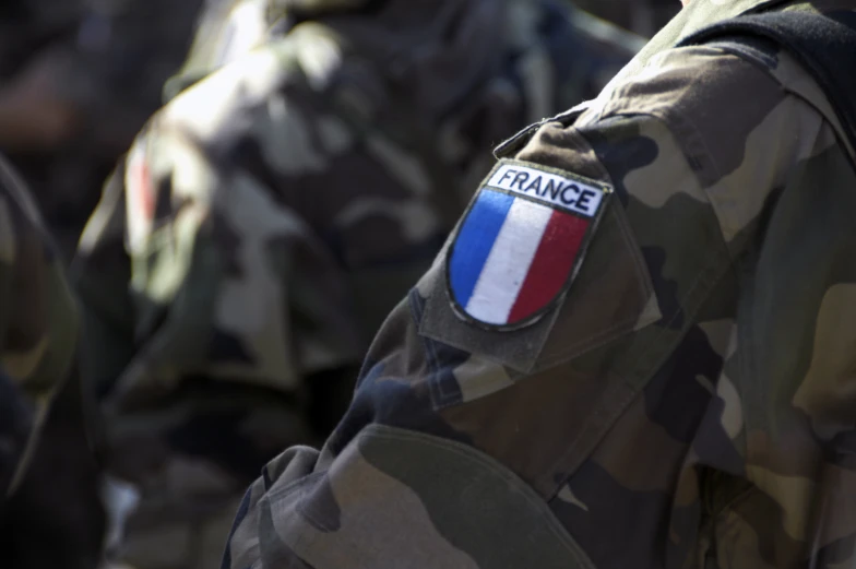 the france flag is seen on a camouflaged shirt