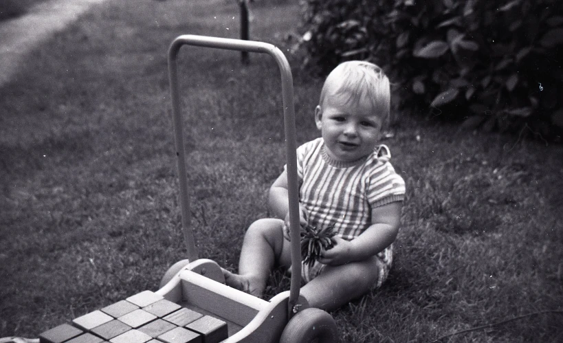 a little boy is sitting down on the lawn