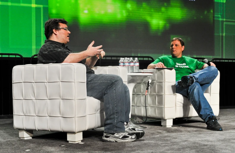 two people sit down in chairs talking