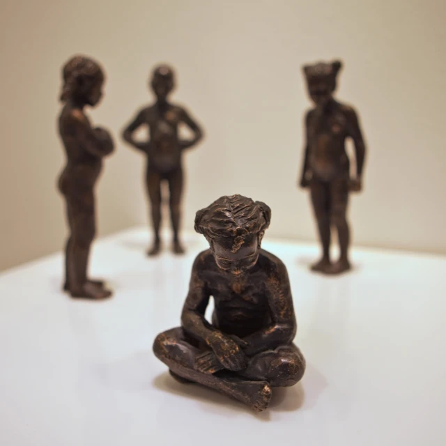 figurines of children sit on a table in a gallery