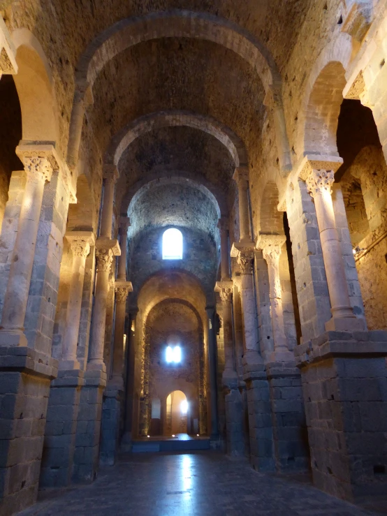 the long passageway is filled with lots of stone pillars