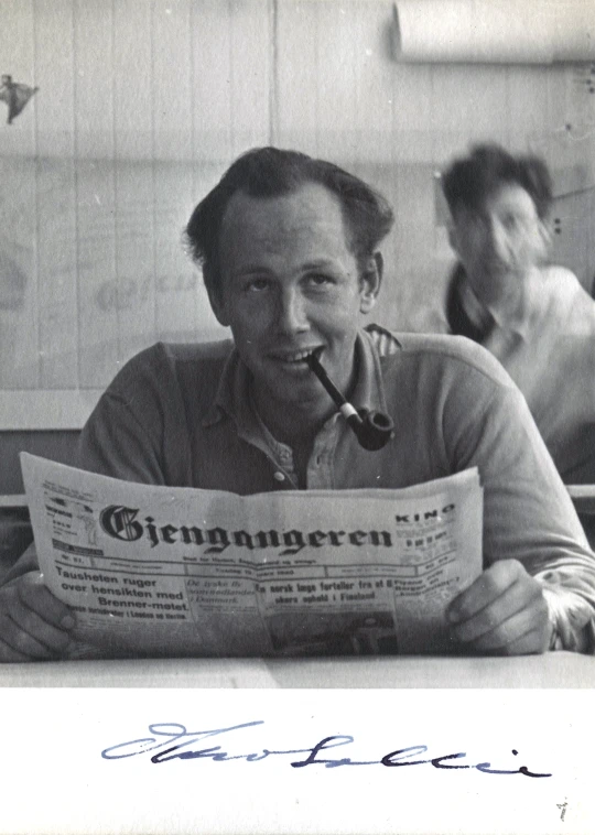 a man with a pipe looks at the news