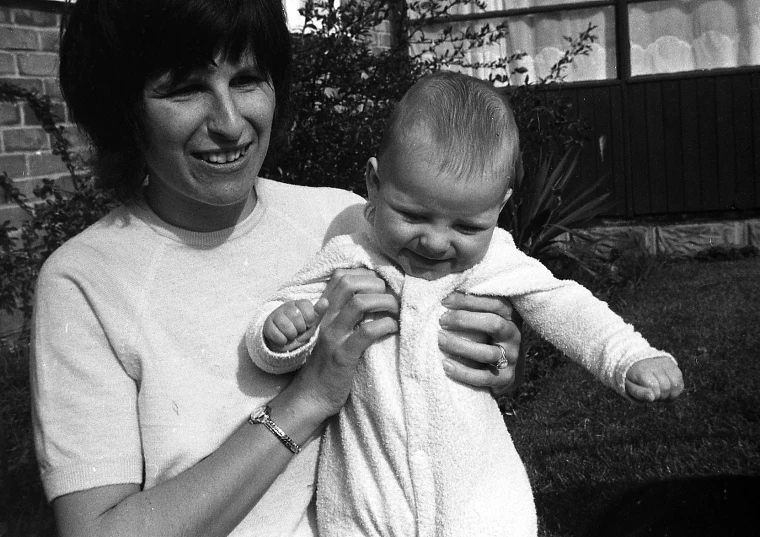 black and white po of a lady holding a baby in her lap