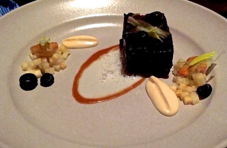 a plate topped with cake, cream and blue berries