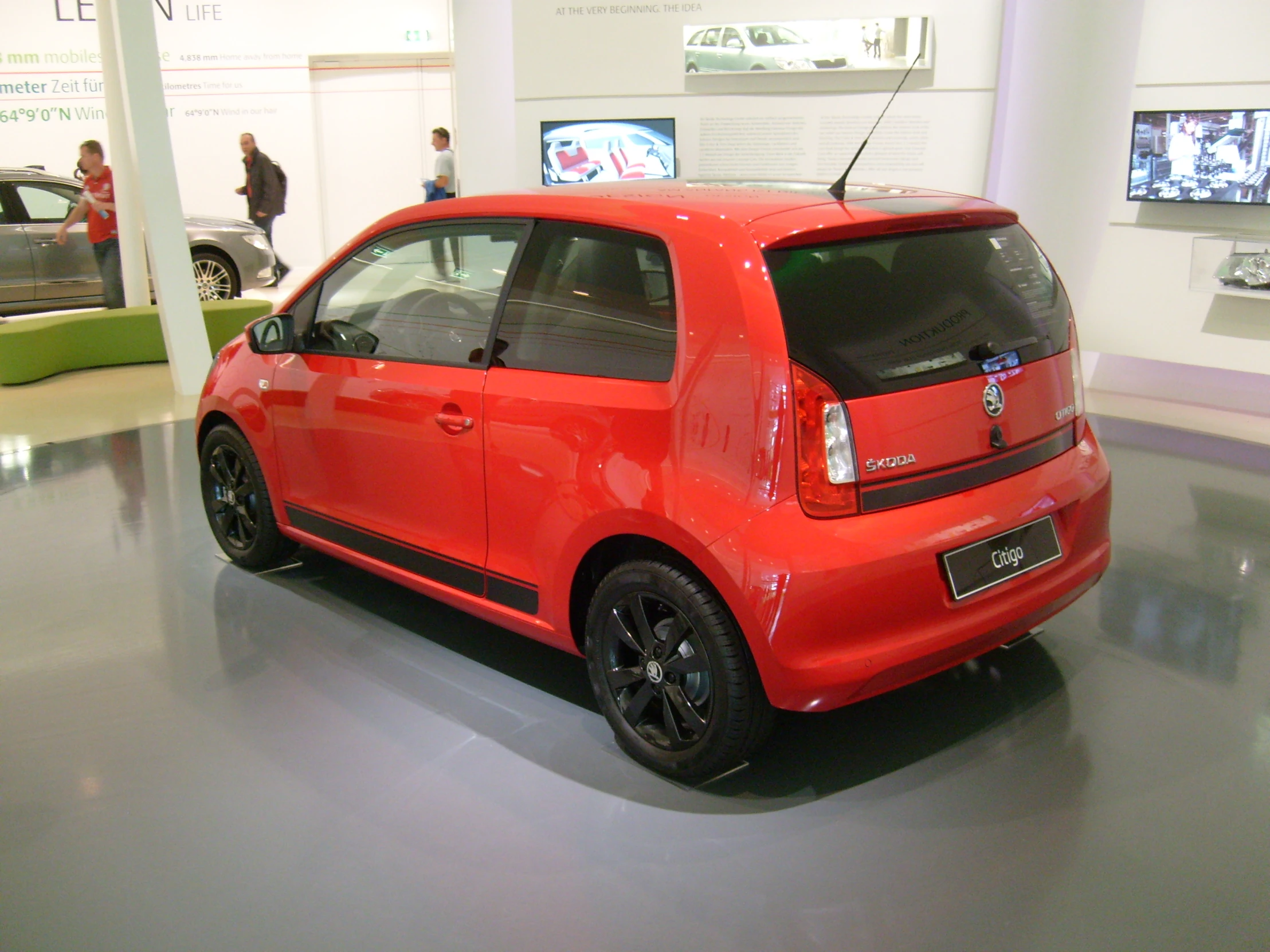 a small car is on display at an exhibition