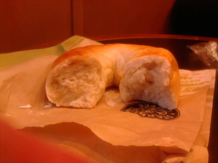 a bagel partially covered with white frosting on top of paper