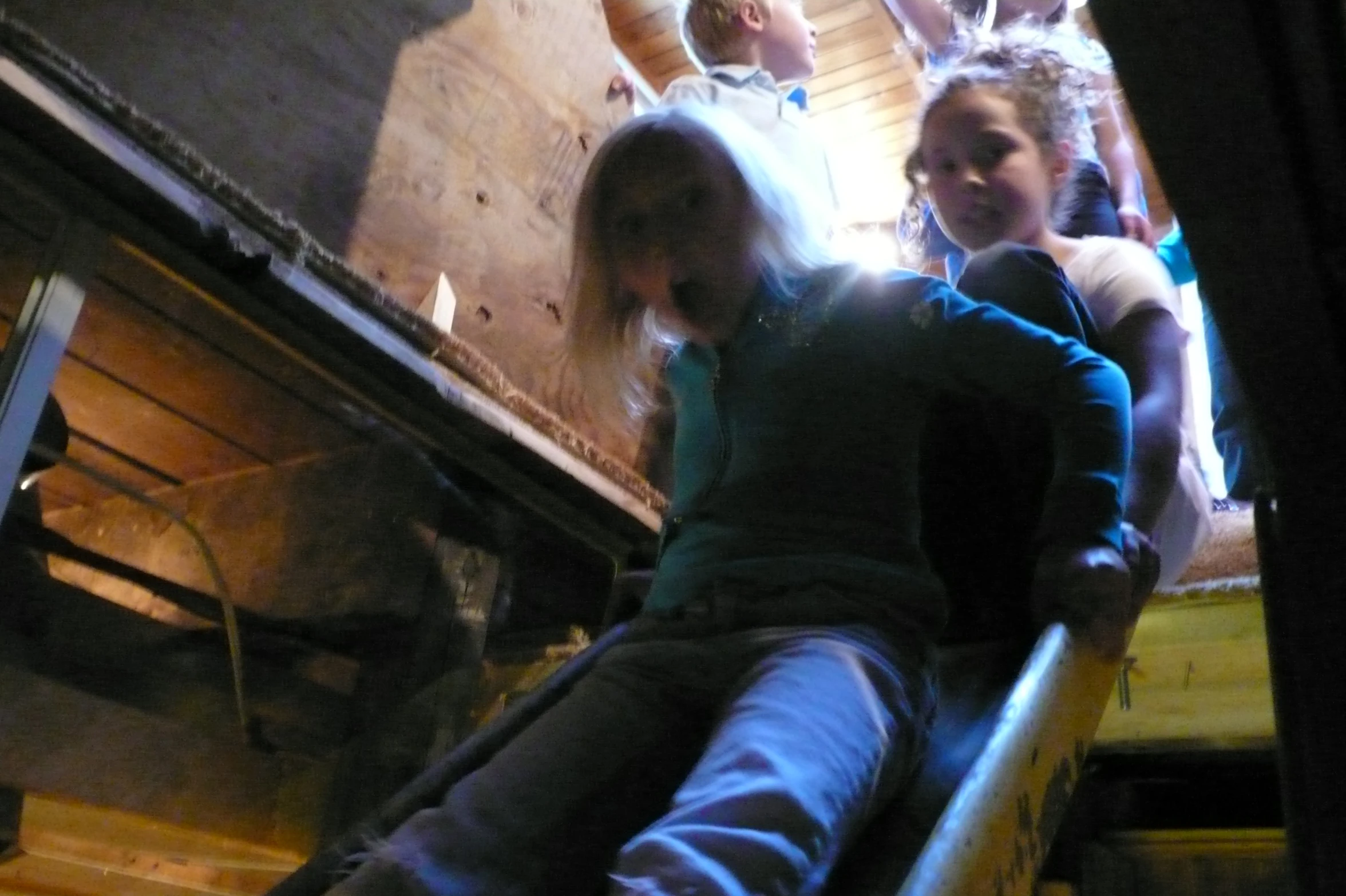 a group of people sit on a wooden slide