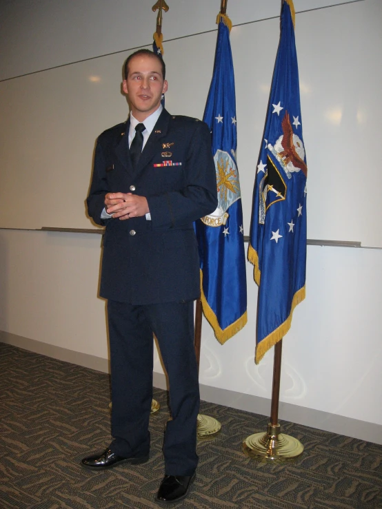 a man in uniform standing next to flags