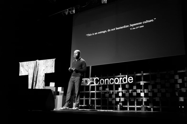 a man in business attire stands on a stage