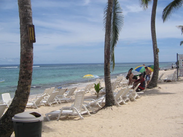 a bunch of chairs and umbrella on the beach