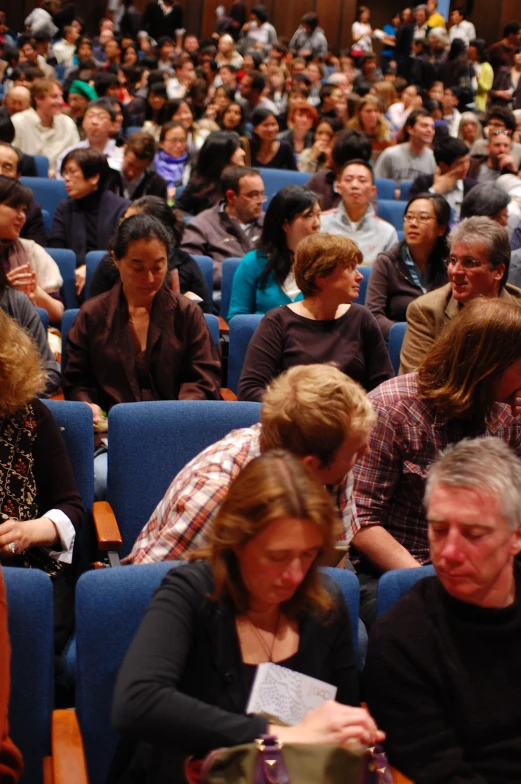 people sitting in rows in a conference hall