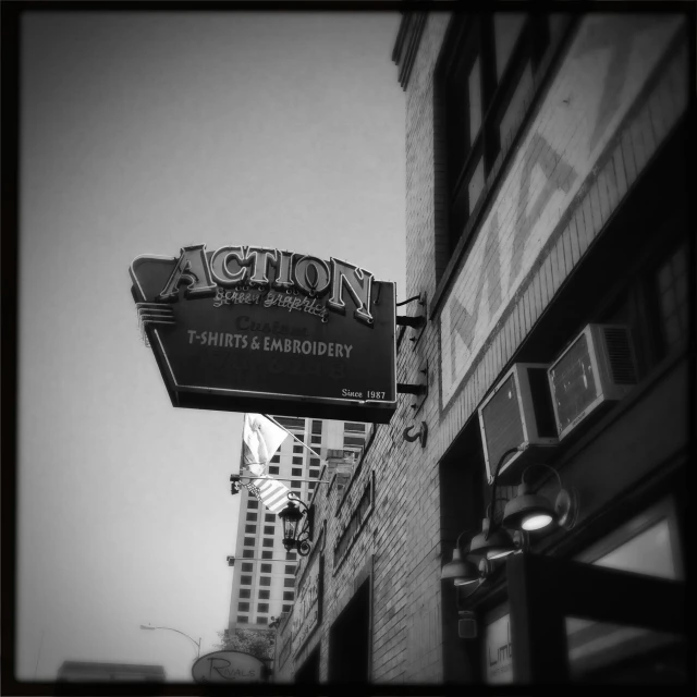 the sign of an action theater with other buildings