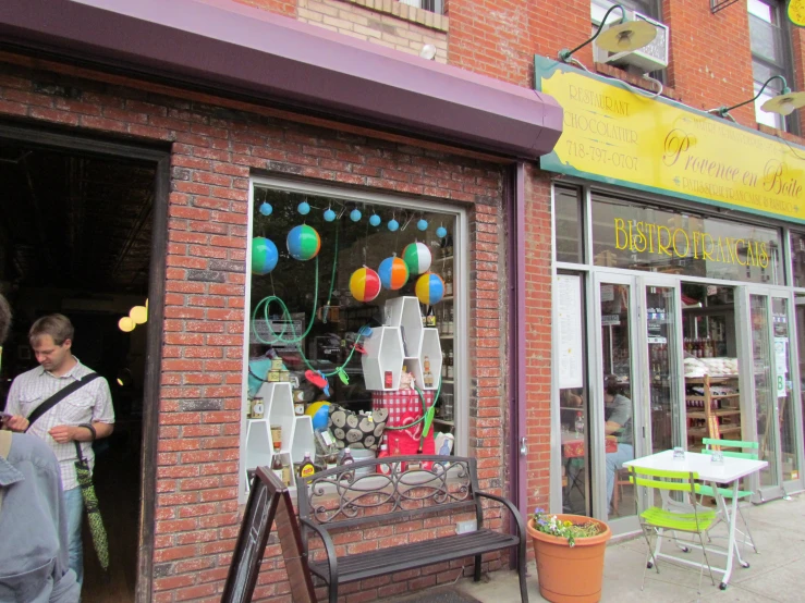 children are walking out of a store window with balloons on it