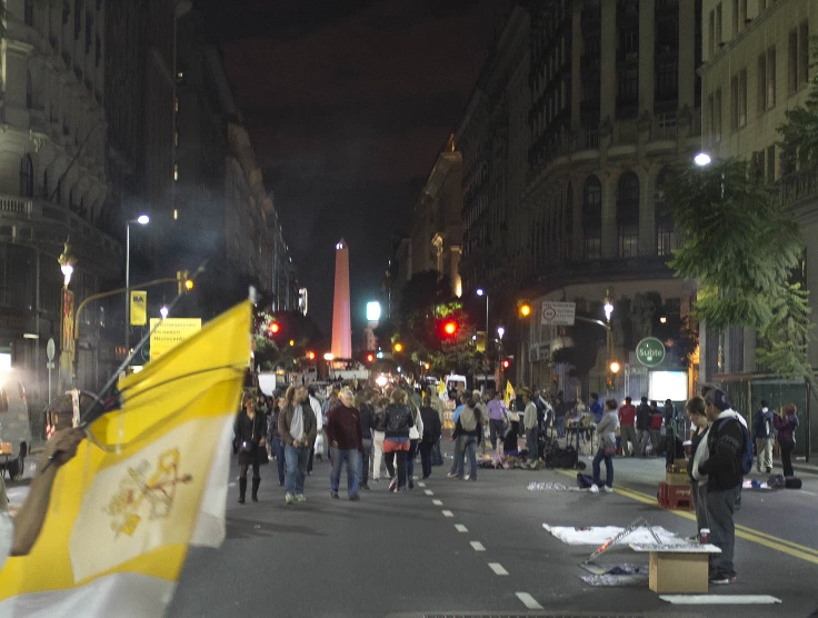 several people walk on a city street at night