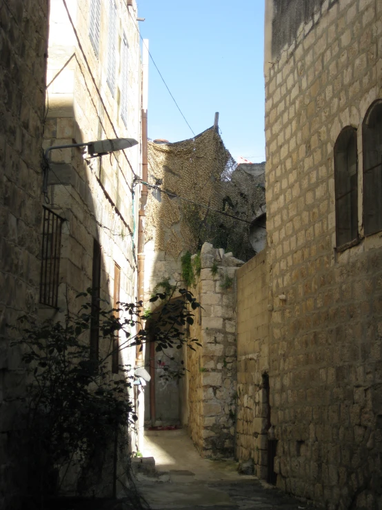 a narrow alley way with an old building on one side and a doorway in the middle