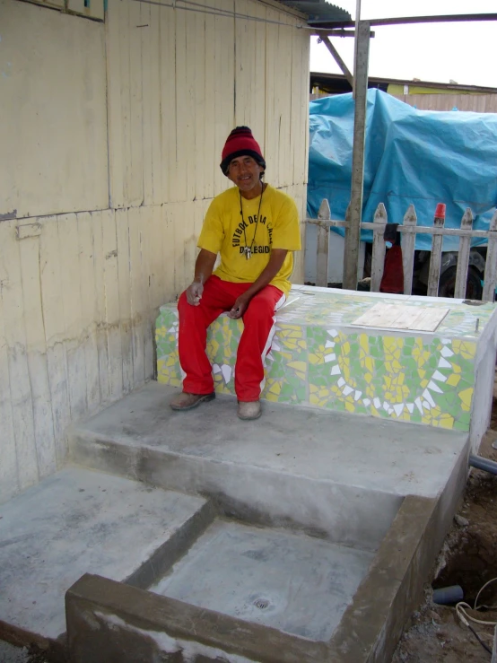 a man wearing red sweat pants sits on some steps