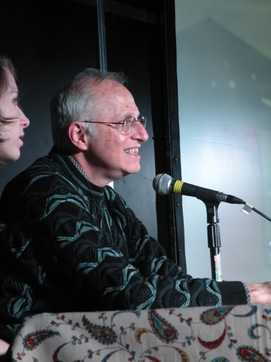 an older man with glasses smiling at soing