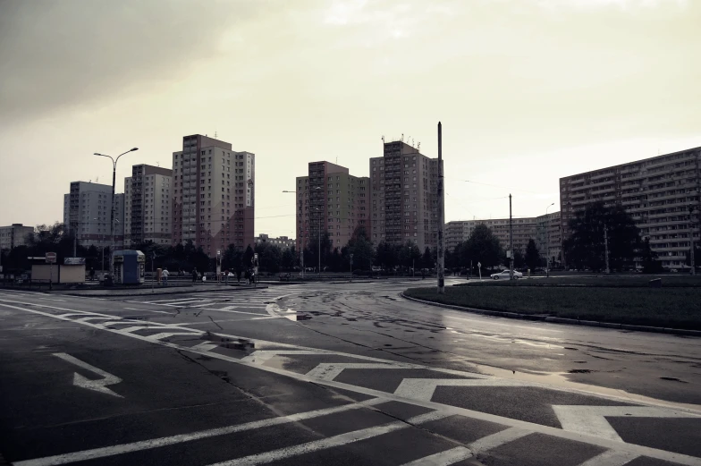 a wet street in front of tall buildings