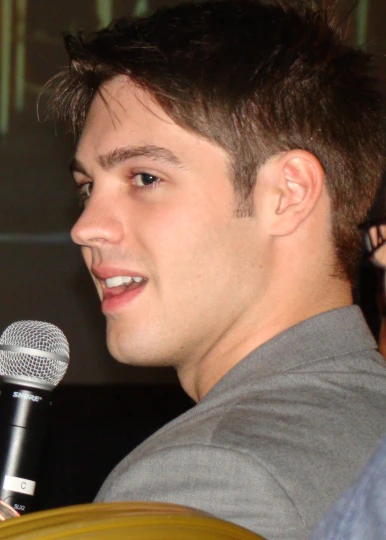 a young man holding a microphone in front of his face
