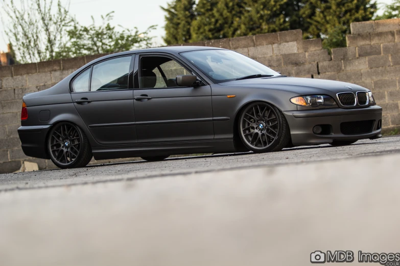 a bmw sits parked in the driveway, looking grey