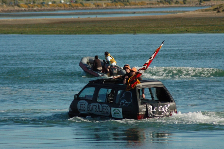 four men waving an american flag from a small boat