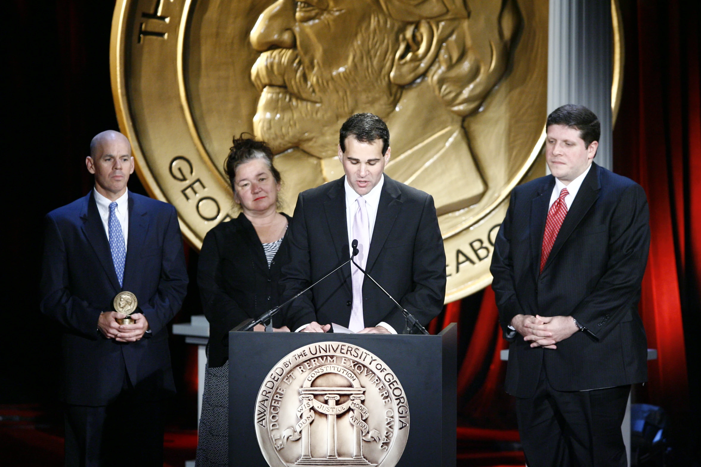 the men are standing behind the podium and talking