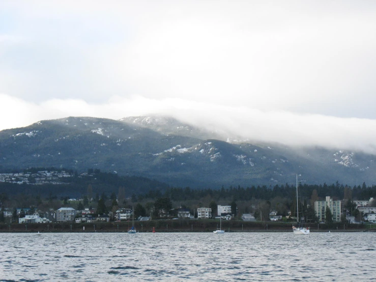 large mountains are seen rising above the blue water