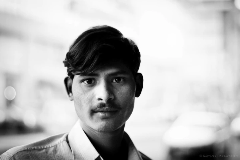 a man standing in front of a building with a white shirt