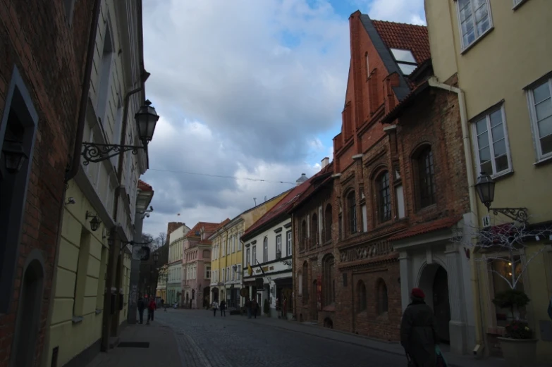 a person walking down a street with a red brick building