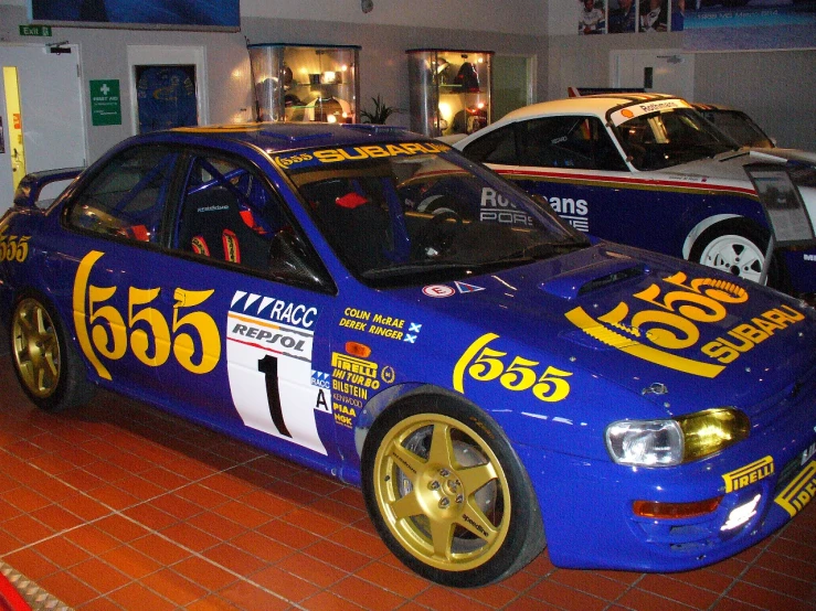 two blue and gold cars in the race museum