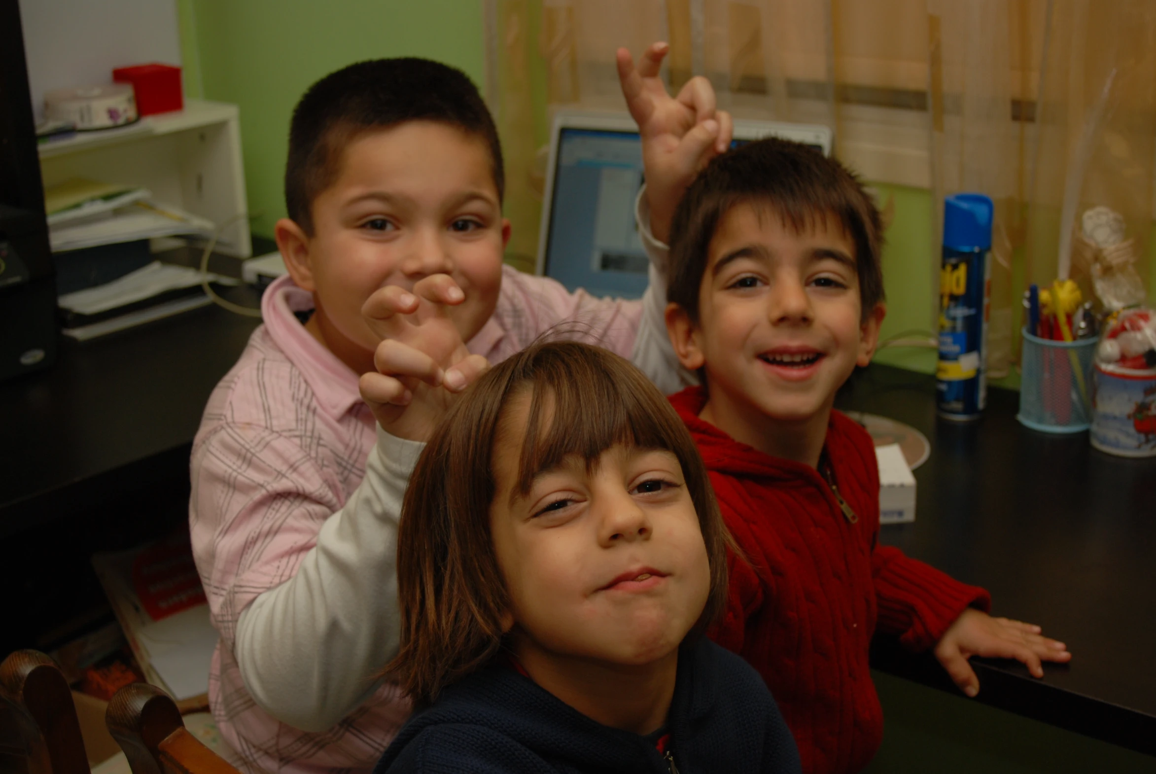 three s with their arms up sit on a chair