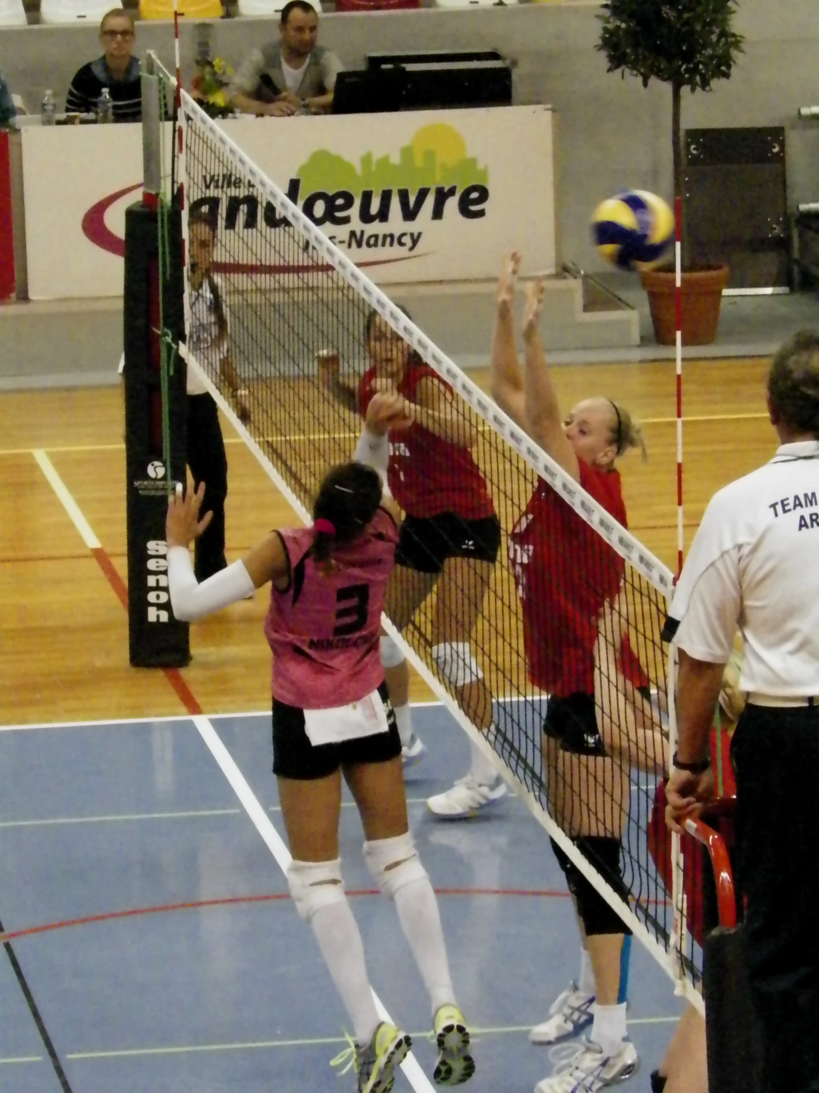 some women playing a game of volleyball in a gym