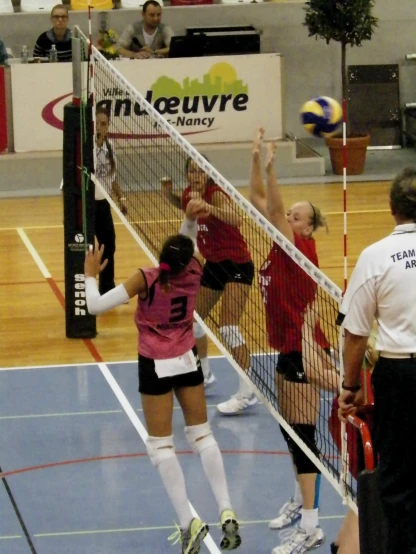 some women playing a game of volleyball in a gym