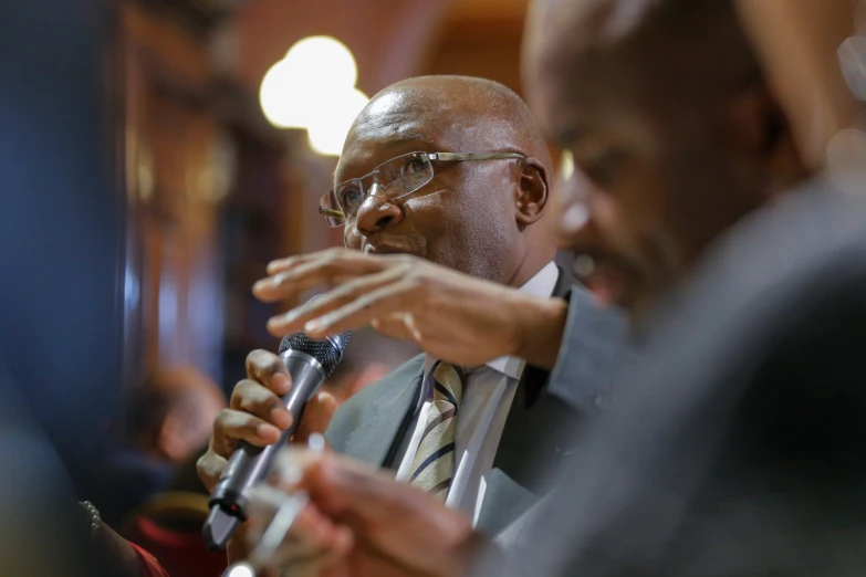 two black men in suits and ties are talking