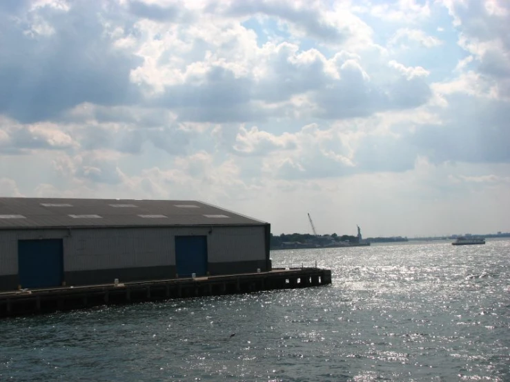 an ocean with a concrete structure and two boats out in the water