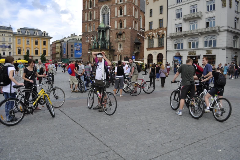 a crowd of bicyclists in an area that looks like a town