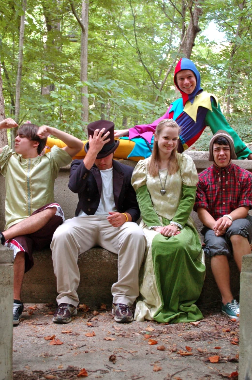 several people sitting on concrete benches, posing for a po