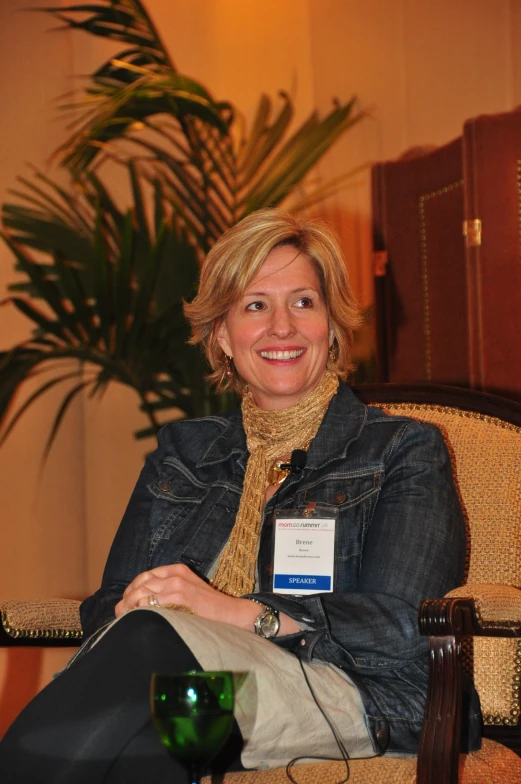 a woman sitting in a chair with a jean jacket over her shoulder