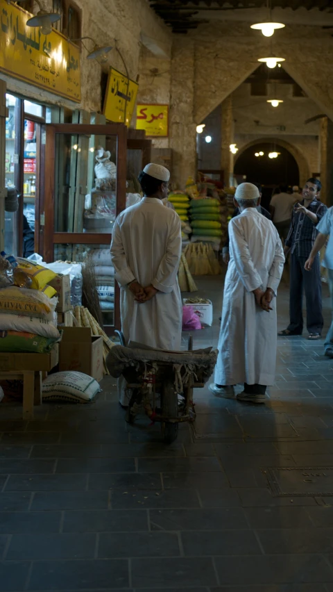 two men in white robes are standing in a store