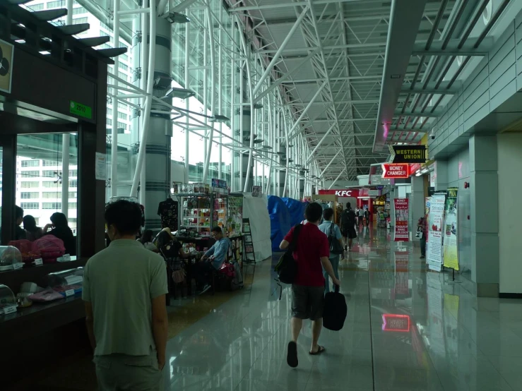 a group of people walk through a building filled with shops