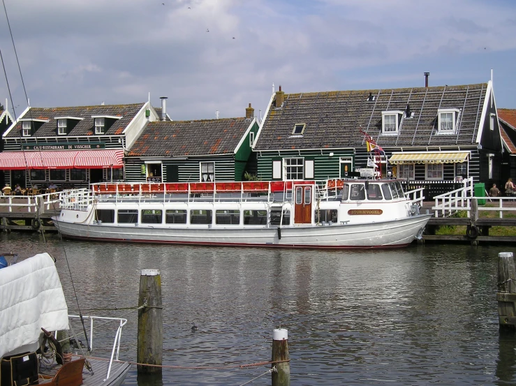 a river boat in front of houses on a dock