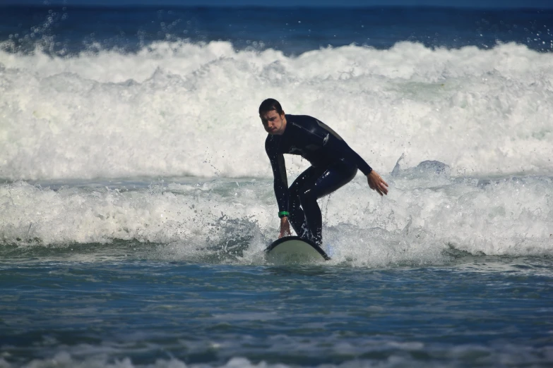 a man in a wetsuit is surfing a wave