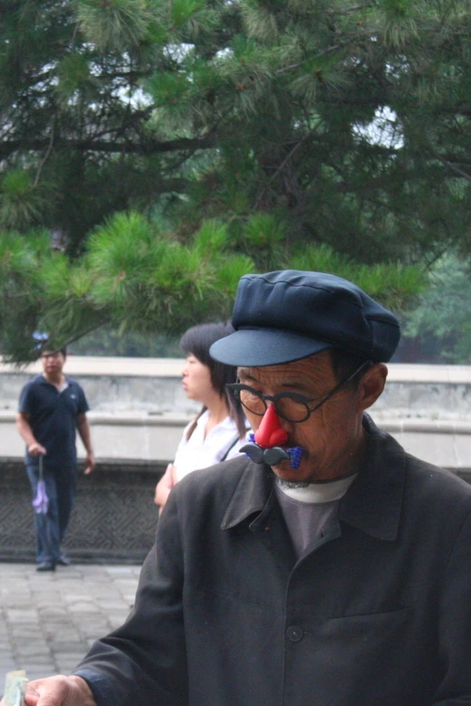 a man wearing glasses and a hat looking at soing