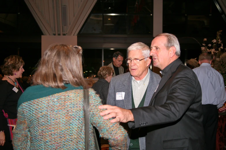 two men are talking at an event