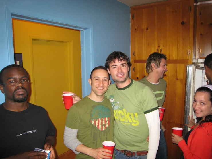 the young men are posing for a po with their cups