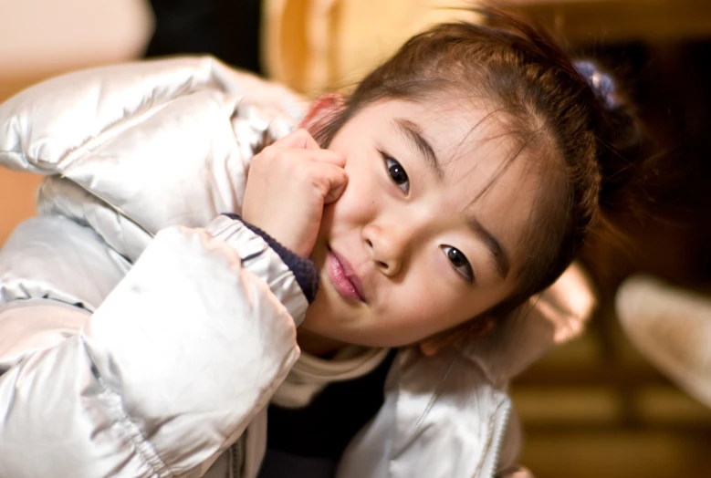 a  wearing a jacket and sitting on a bed